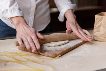 A girl in the kitchen prepares a dough