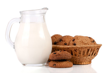 jug and glass of milk with oatmeal cookies in a wicker basket isolated on white background