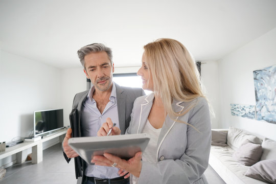 Real-estate agent with client visiting modern house