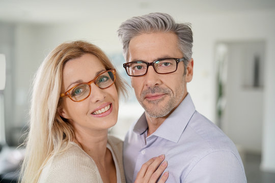 Portrait of cheerful middle-aged couple with eyeglasses on