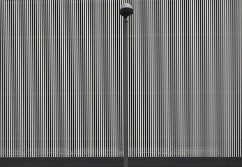 Gray aluminum striped wall  with a street lamp in front. Background and texture