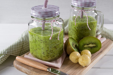 Fresh and healthy green Juice smoothie with kiwi and banana in glass jar. On white background . 