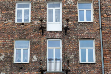 Fototapeta na wymiar Window on the brick facade of an old house