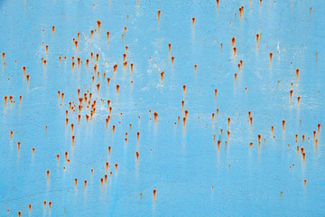 Old blue metal wall with rust specks