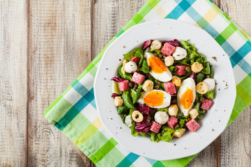 Delicious Italian salad with salami, egg, crostini and mozzarella.