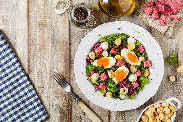 Delicious Italian salad with salami, egg, crostini and mozzarella.
