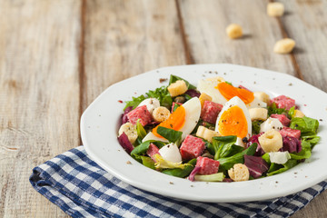 Delicious Italian salad with salami, egg, crostini and mozzarella.