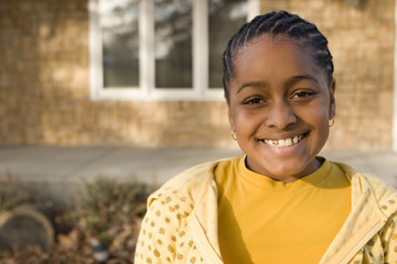 Happy African American young girl smiling outside.
