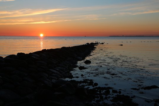 malerischer Sonnenaufgang an einer Steinmole an der Ostsee