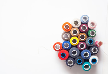 Colored thread coils on white background, sewing tools