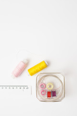 Colored thread coils on white background, sewing tools