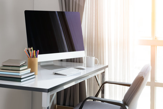 Blank computer desktop with keyboard, diary and other accesories on white table