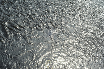 Water background texture with sun light. Angel View. Abstract blue water sea for background.