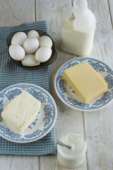 Dairy products on wooden table. Sour cream, milk, cheese, egg, yogurt and butter. Top view