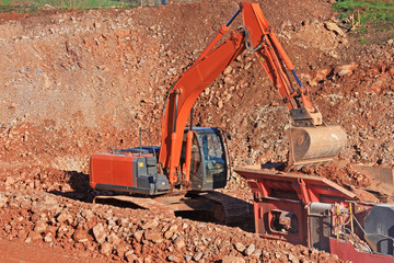 Digger loading a stone crusher