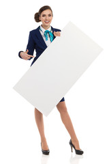 Smiling Air Stewardess Holding White Placard And Pointing