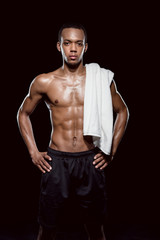 Fototapeta na wymiar portrait of confident african sporty man with towel on shoulder on black
