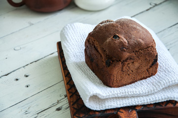 Rye bread with dry fruits filling on a wooden board with white towel. White background.