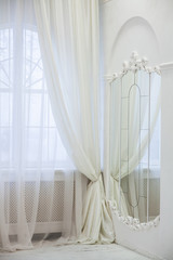 mirror created from the lot of mirrors with gypsous frame, big windows and curtain