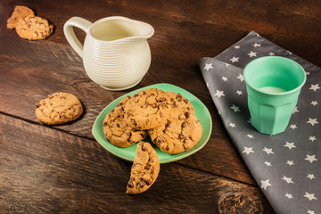 Chocolate chips cookies with glass and jar of milk