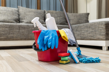 Cleaning service. Bucket with sponges, chemicals bottles and mopping stick. Rubber gloves and...