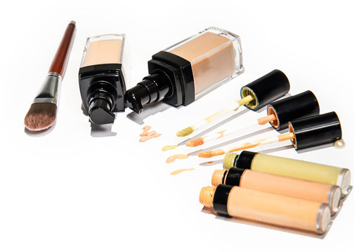 Light beige color liquid concealer closed and open bottle and brush, used for covering blemish on the skin, isolated on white background, with clipping paths