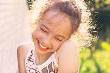 Happy Little girl excited. Cute preteen Girl smiling very happy, surprised  on Summer background. Beautiful Child joyful at Sunset.