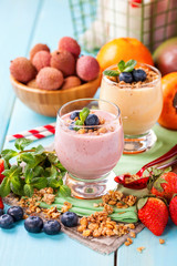 Blueberry orange persimmon  smoothie with granola  and fruits. Selective focus. Copy space. Top view
