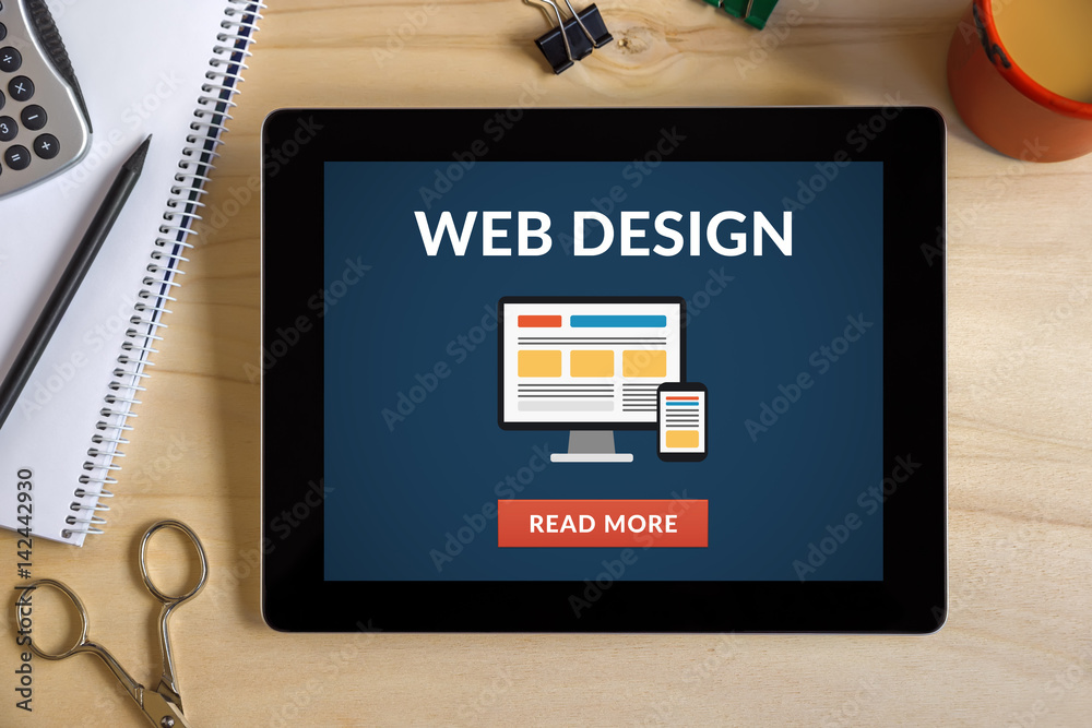Wall mural web design concept on tablet screen with office objects on wooden desk. all screen content is design
