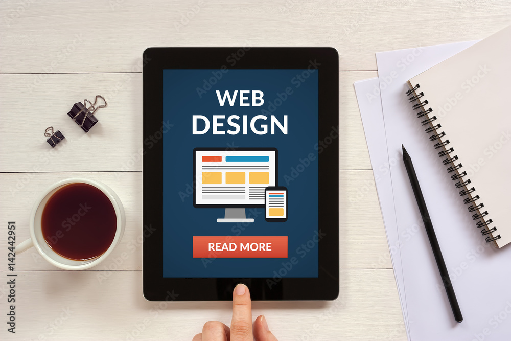 Wall mural web design concept on tablet screen with office objects on white wooden table. all screen content is