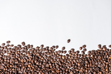 Top view of roasted coffee beans on white background