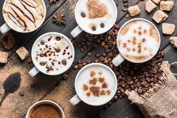 top view of cups of coffee, coffee beans, cookies and spices on table