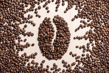 Close-up top view of coffee bean symbol made from roasted coffee grains on table
