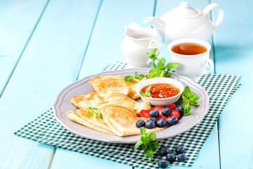Pancakes with jam and berries on a table. Selective focus.  Copy space.