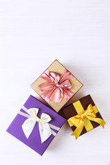 Fototapeta na wymiar Gift boxes with bow. Colored presents wrapped with paper and ribbons. Christmas or birthday packages. Celebration design. On white table.