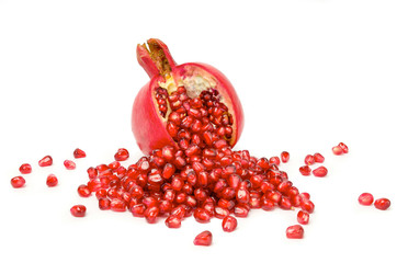 pomegranate with scattered grains on white background.