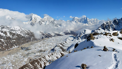 Beautiful panoramic evening view of the Gokyo valley and Cho-Ou glacier from the top of the Mt. Gokyo Ri, Nepal. Blue sky and white clouds on the background.
