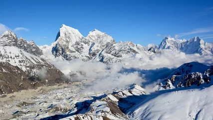Papier Peint photo Makalu Vue majestueuse sur les montagnes himalayennes depuis le mont Gokyo Ri. Chaîne de montagnes couverte de neige sur fond de ciel bleu.