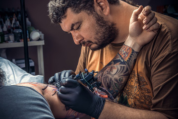 Professional tattoo artist posing in tattoo studio