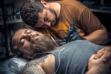 Professional tattooer create tattoo in tattoo studio