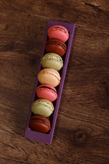 Macaroon cakes. Different types of macaron. Colorful almond cookies. French sweet dessert. Wooden rustic board.