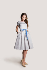 beautiful young girl in a dress on a light background