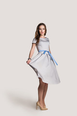 beautiful young girl in a dress on a light background