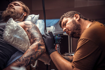 Professional tattoo artist create tattoo in tattoo parlor