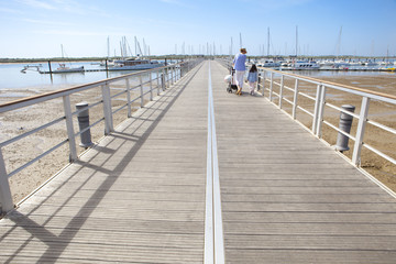 Fototapeta premium People walking by footbridge at marina, Huelva, Spain