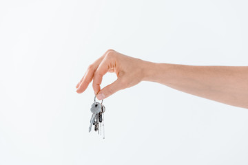 partial view of hand holding keys from new house on white