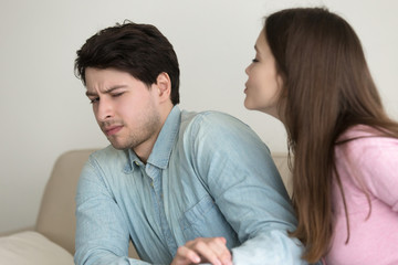 Fototapeta premium Pretty girl trying to kiss a man and he rejecting lady, not interested and turning away confused, bad blind date, humorous flirting, faithful husband, misunderstood, unsuccessful woman initiative