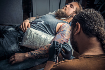 Professional tattooist at work in studio