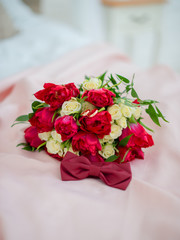 Close up of wedding bouquet of red tulips and white roses, wedding rings and butterfly bouquet to match