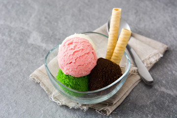 Ice cream scoops in crystal bowl on gray stone

